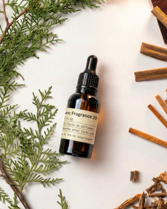Charabanc Fragrance NO.29 Santal essential oil bottle styled with fresh green pine branches, sandalwood sticks, and leather accents for a cozy ambiance.