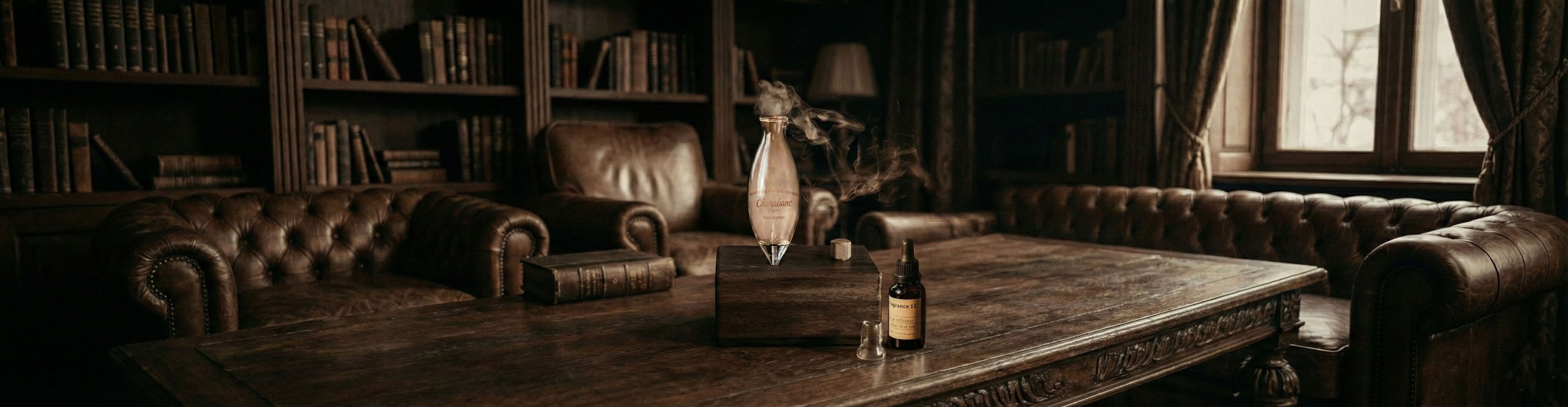 "A wide cinematic banner featuring the Charabanc waterless diffuser on a vintage oak table in a classic private library. The scene includes dark leather Chesterfield sofas, floor-to-ceiling bookshelves, and a bottle of Santal 26 essential oil, with a delicate wisp of aromatic vapor rising from the hand-blown glass nebulizer in the warm, moody light."