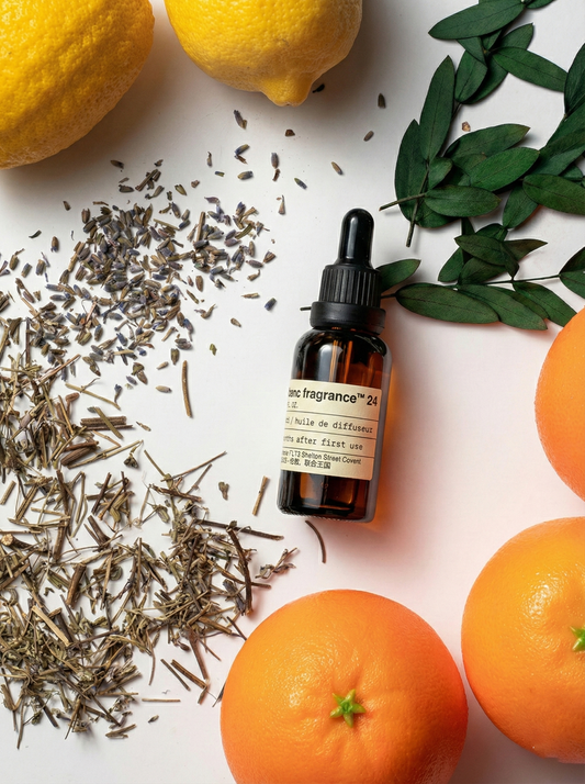 Charabanc Fragrance NO.24 Midnight Voyage essential oil bottle styled with fresh oranges, lemons, dried lavender buds, and green leaves, representing a bold citrus and floral blend.